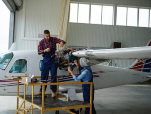 Male technician asking his female colleague for another wrench in blog of Airborne Crisis in the Aviation Industry by sunteur renewables